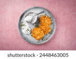 Traditional parsnip potato pancakes with chives and quark dip served as a top view on a Nordic Design plate with text space 