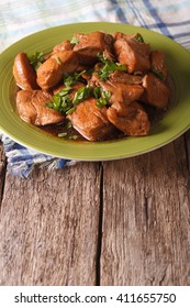 Traditional Philippine Food: Adobo chicken with herbs close-up on a plate on the table. vertical