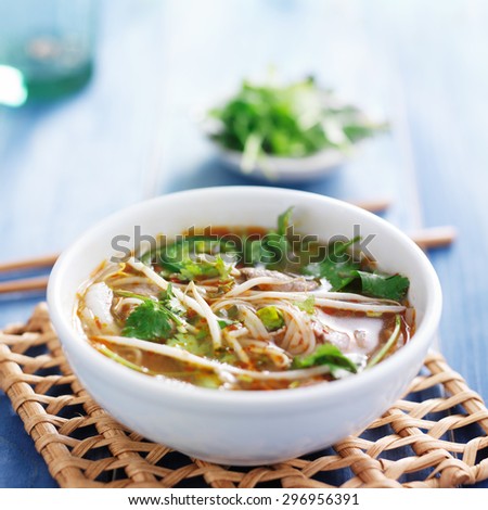 traditional pho tai beef vietnamese soup in bowl with cilantro and bean sprouts