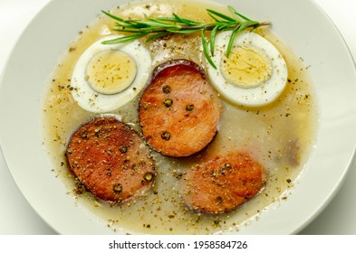 Traditional Polish Sour Soup With Sausage And Eggs In A White Deep Plate, Eastern European Meal