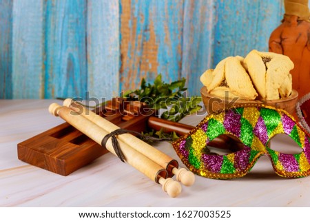 Traditional Purim celebration jewish carnival holiday cookies hamans ears, noisemaker and mask