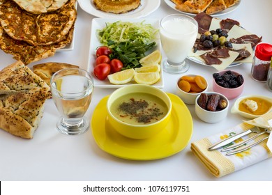 Traditional Ramadan Dinner Iftar Table With Traditional Turkish Green Lentil Soup In Yellow Bowl On White Table With Other Foods