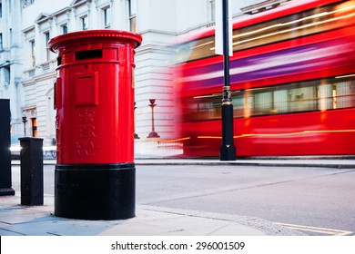 Traditional Red Mail Letter Box And Red Bus In Motion In London, The UK. Symbols Of The City And England