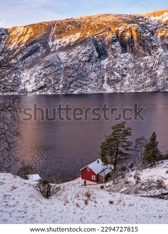 Traditional red Norwegen house on a fjorf in Stanghelle, Norway