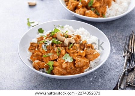 Traditional red thai chicken curry with cashews and herbs served with white rice