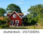 Traditional red wooden house in Sweden on the island Oland, in the summer. The house is surrounded by a beautiful, summery garden