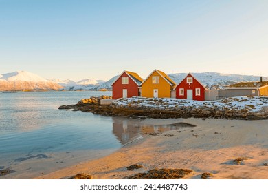 Traditional red and yellow wooden norwegian cabins with ground on the roof. Tromso, Norway - Powered by Shutterstock