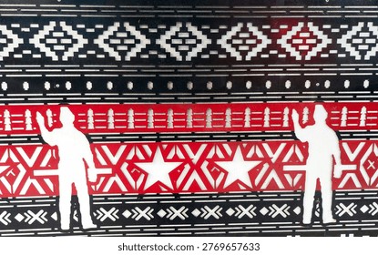 A traditional red-and-black pattern featuring two white figures adorns the wall of an office building in Jakarta