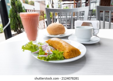 traditional restaurant breakfast with tamale, fruit juice and bread