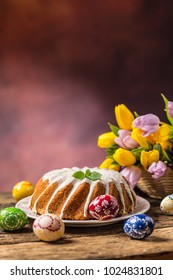 Traditional ring marble cake with easter decotation, eggs and spring tulips.