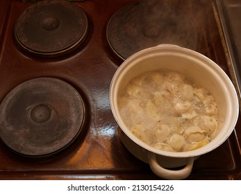 A Traditional Russian Dish Of Dumplings Is Cooked In A Pot On An Old Stove. Top View