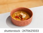 Traditional Russian Fish Soup with Two Varieties of Fish in Rustic Earthenware Bowl.