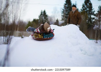 Traditional Russian Holiday In Early Spring. Seeing Off Winter. Mardi Gras. Family With Children In Winter In The Park.