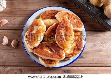 Traditional Russian pies with potatoes. Russian pirozhki, homemade baked patties. Top view