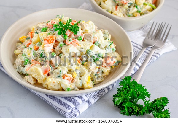 Traditional\
Russian salad Olivier in a Bowl High Angle, White Background,\
Popular Russian Food Horizontal Stock\
Photo