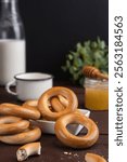 Traditional russian snack bagels with milk and honey on wooden table. Popular flour dessert