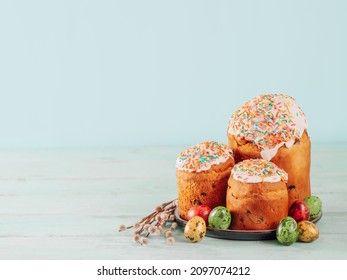 Traditional Russian Ukrainian Easter Cake Kulich. Orthodox Christian Easter Bread or Easter Cake with frosting, Easter Eggs and willow twigs on blue background. Copy space for text, place for design