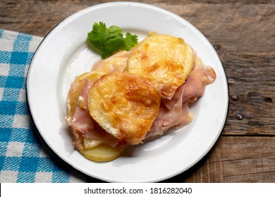 Traditional Scalloped Potatoes With Ham And Cheese On Wooden Background