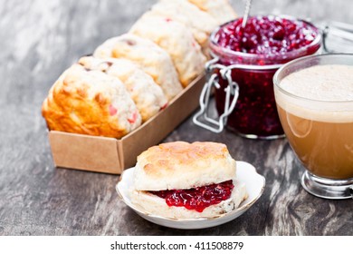 Traditional  scone with raisins filled raspberry jam and cup of coffee 
