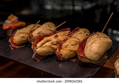 Traditional serrano iberico ham sandwiches or bocadillo on a platter on display in a restaurant, San Sebastian Donostia, Basque Country, Spain
