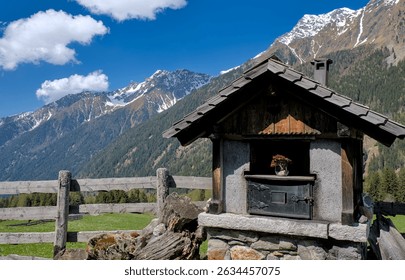 Traditional shepherd's cottage with an external fireplace in the Antholz Valley, South Tyrol, Italy. Located in the High Tauern range of the Central Eastern Alps.