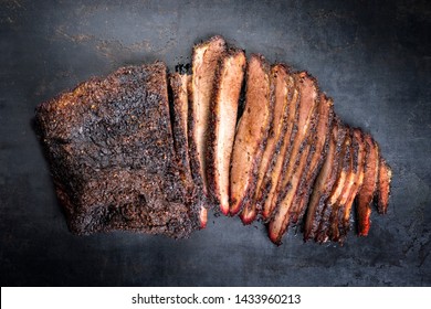 Traditional smoked barbecue wagyu beef brisket offered as top view on an old rustic board with copy space 