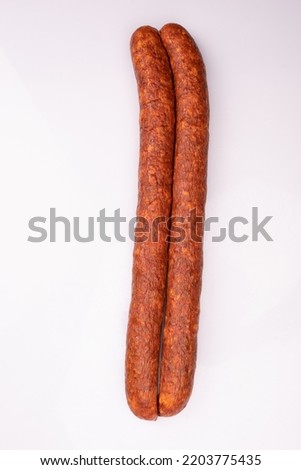Traditional smoked pork sausage, long, isolated, top view. Polish meat sausage, cold cuts, a packshot photo for package design, template. 