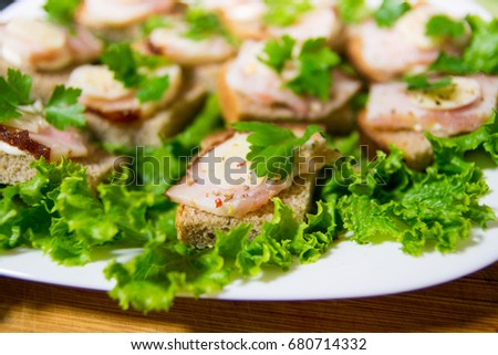 Traditional snack for Russian and Ukrainian people on the holidays. A sandwich with bacon, garlic and parsley under the glass of genuine Russian vodka

