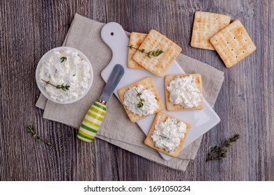 Traditional Soft Cheese With Thyme And Crackers On A Wooden Background. Selective Focus.