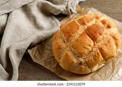 Traditional Sourdough Boule On Butcher Paper, Above Rustic Wooden Table 