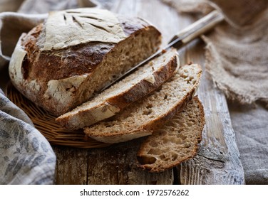 Traditional sourdough bread, sliced on a wooden board, close-up view