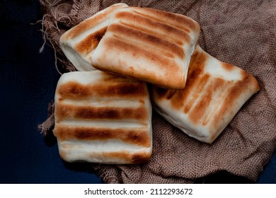 Traditional South African Braai bread or roosterbrood, cooked on open flame with rustic style background