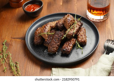 Traditional South European Skinless Sausages Cevapcici Made Of Ground Meat And Spices On Black Plate On Dark Wooden Board, With Thyme