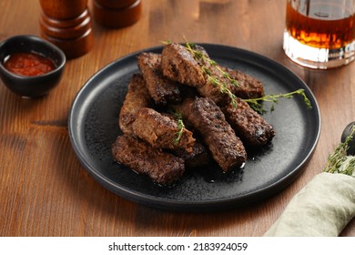 Traditional South European Skinless Sausages Cevapcici Made Of Ground Meat And Spices On Black Plate On Dark Wooden Board, With Thyme