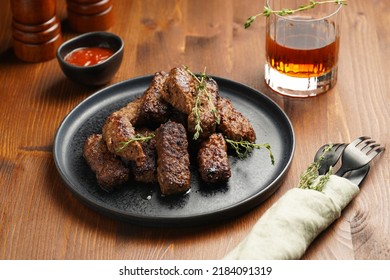 Traditional South European Skinless Sausages Cevapcici Made Of Ground Meat And Spices On Black Plate On Dark Wooden Board, With Thyme