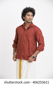 Traditional south Indian young man posing on white.