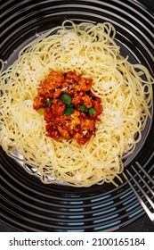 Traditional Spaghetti Bolognese. Food Composition With Hot Pasta In A Black Plate With Fork. Mediterranean, Italian Food, Simple Dish. Flat Lay, Closeup