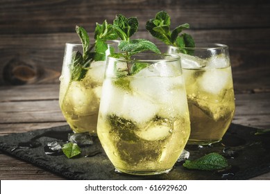 Traditional Spanish Alcoholic Drink, Rebujito Cocktail - White Wine, Carbonated Water (soda), Mint, Lemon Juice. On A Rustic Wooden Table, Three Glasses. Copy Space