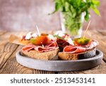 Traditional Spanish Jamon Serrano ham, Prosciutto Crudo, Parma ham, Italian antipasto, served on toasted bread.