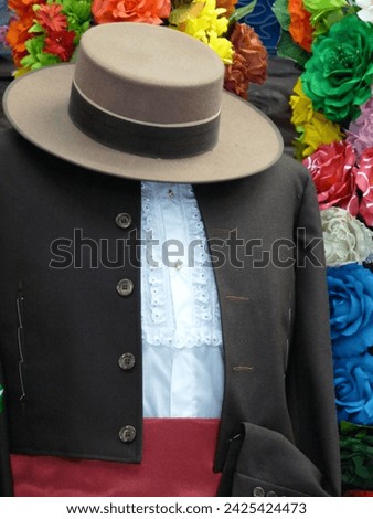 Traditional Spanish male flamenco costume with short black jacket, frilly white shirt, and flat wide-rimmed hat in Madrid shop window display