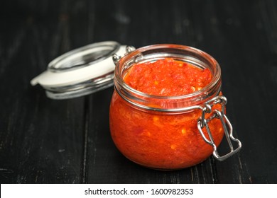 Traditional Spicy Harissa Sauce In A Glass Jar On A Dark Background. Maghreb Cuisine.