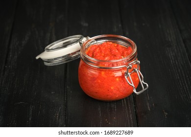 Traditional Spicy Harissa Sauce In A Glass Jar On A Dark Background. Maghreb Cuisine.