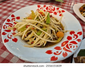 Traditional spicy papaya salad with fermented fish sauce, green bean, lime, peanut and tomato serving on the plate. Famous local street food menu in Thailand. Popular low fat menu for diet. - Powered by Shutterstock