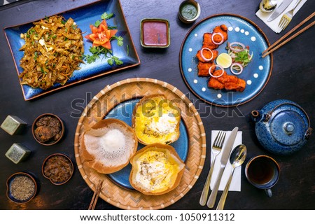 Traditional Sri Lankan kottu roti, hoppers cake, chicken spicy tikka boti in wooden background