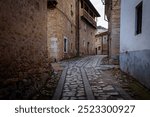 Traditional stone houses on a cobbled street with the natural cliff surrounding Orbaneja del Castillo, Burgos, Spain