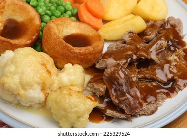Traditional Sunday roast dinner with Yorkshire puddings and gravy.