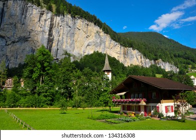 Traditional Swiss Chalet And Church Bell