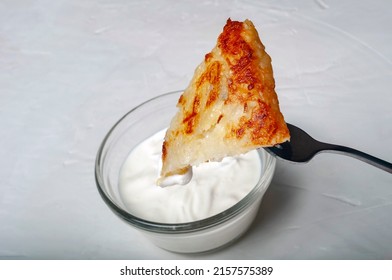 Traditional Swiss Dish Is Strung On A Fork - Part Of A Potato Pancake Is Strung On A Fork And Lowered Into A Saucepan With Cream Sauce.