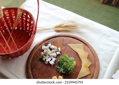 Traditional Table For Shavuot, Jewish Holiday Celebrating Wheat Harvest, With Cheese Platter, Red Wicker Basket And Wheat Stalks