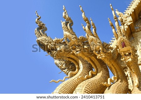 Traditional thai dragon statue against blue sky at a temple in Thailand